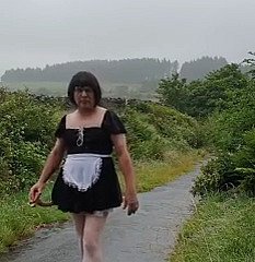 Transvestitenmädchen in all directions einer öffentlichen Gasse im Regen